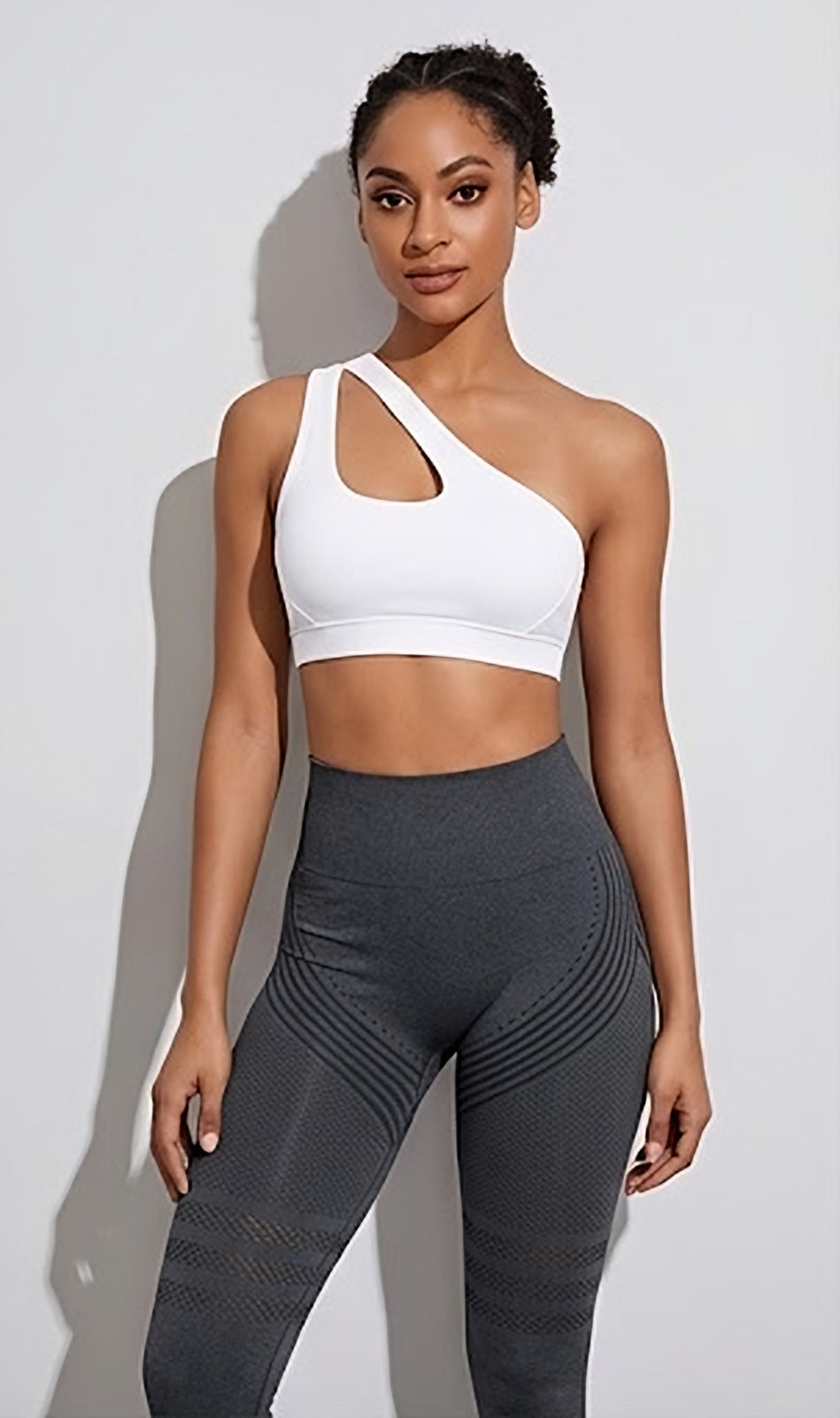 Brassière asymétrique blanche portée avec le legging gris